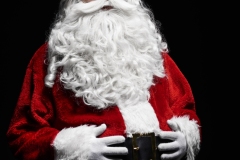 Portrait of cheerful santa claus with hands on stomach
